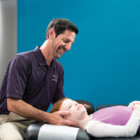 The Joint Chiropractic Wellness Franchise Opportunity chiropractor doing spinal adjustment on young girl