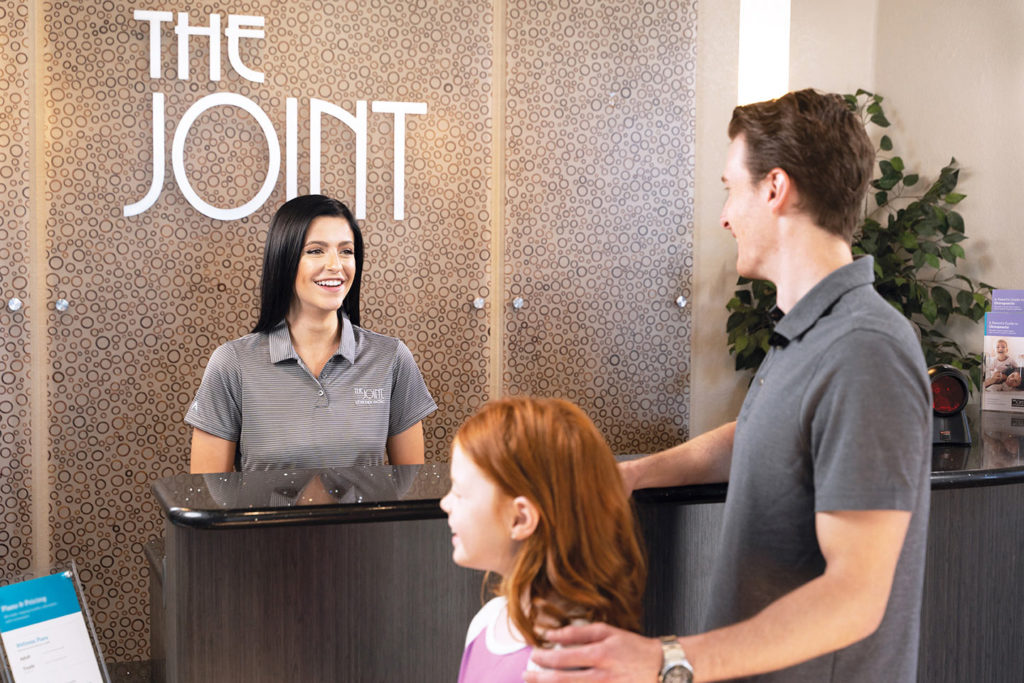 The Joint Chiropractic health franchise customers talk to receptionist